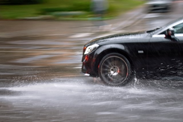 „Schleudergefahr“-Schild als Warnzeichen für Aquaplaning